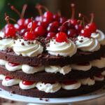 Fertige Schwarzwälder Kirschtorte mit Schokoladenbiskuit, Sahne, Kirschen und Schokoraspeln auf einer Kuchenplatte.